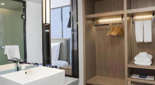 une salle de bains avec un lavabo blanc et un miroir dans l'établissement Echarm Hotel Lhasa Potala Palace, à Lhasa