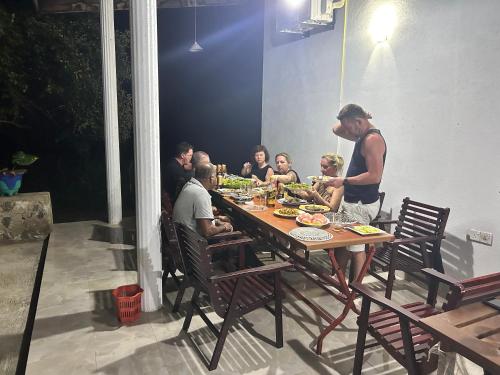 Eine Gruppe von Menschen, die an einem Tisch sitzen und Essen essen. in der Unterkunft Neem safari lodge Yala in Tissamaharama
