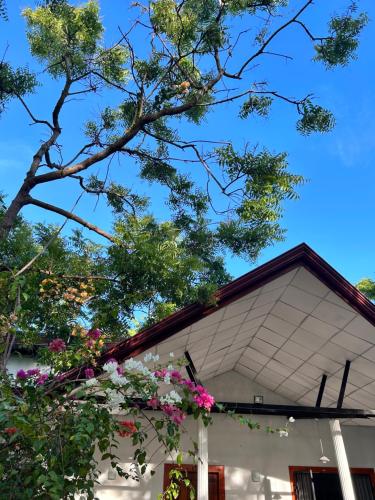 ein weißes Haus mit Blumen davor in der Unterkunft Neem safari lodge Yala in Tissamaharama