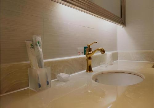 une salle de bain avec un lavabo et un robinet dans l'établissement City Comfort Inn Zhanjiang Mazhang Pedestrian Street High-speed Railway West Station, à Tchia-k'am
