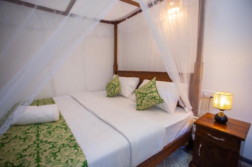 a bedroom with a bed with a canopy at The Mud Crab 80 in Ahangama