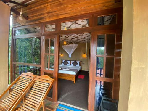 ein Schlafzimmer mit einem Bett in einem Zimmer mit Glastüren in der Unterkunft Nice View guest house & restaurant in Ella