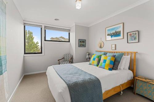 ein Schlafzimmer mit einem Bett und zwei Fenstern in der Unterkunft The Pattern House Ballarat Lakeside Creative Haven in Eureka