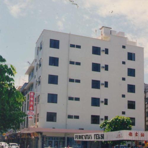 Hotel Kinabalu في كوتا كينابالو: مبنى ابيض كبير امامه لافته