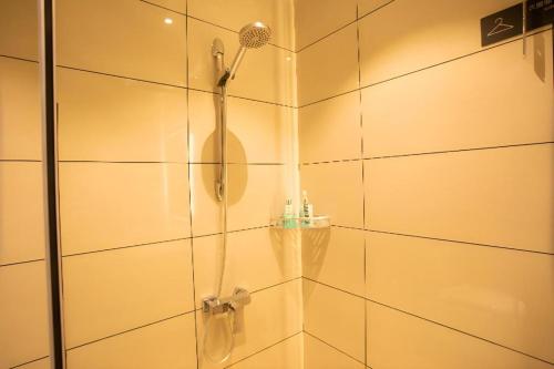 eine Dusche mit Duschkopf in einem Badezimmer in der Unterkunft City Comfort Inn Huaihua East Station in Huaihua