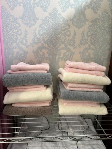 出云市一棟貸しゲストハウス マリドール的浴室内架上的毛巾堆