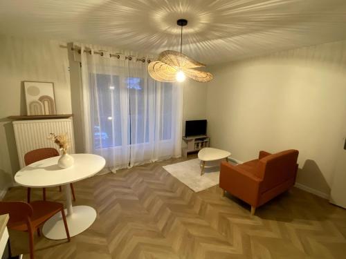 a living room with a couch and tables and a chandelier at Charming 2-room apartment, Grand Annecy in Meythet