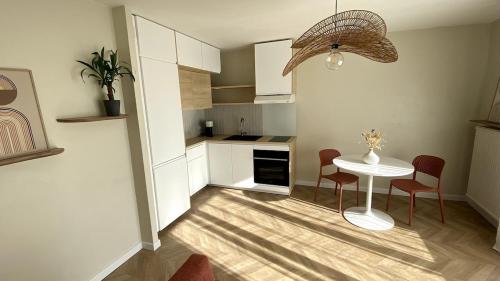 a kitchen with a table and two chairs and a table at Charming 2-room apartment, Grand Annecy in Meythet