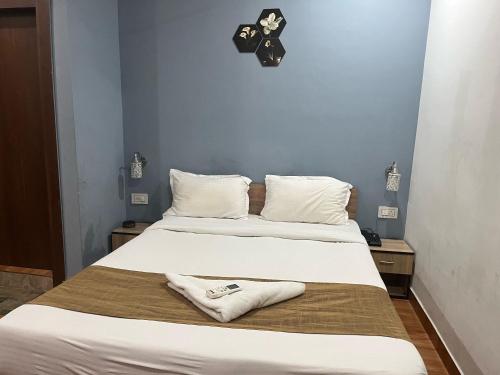 DispurTownhouse Lalmati National Highway 27 Formerly The Pinnacle Inn的一间卧室，墙上有两张床和一只钟