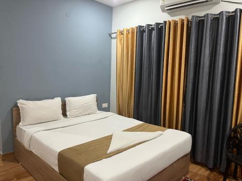 DispurTownhouse Lalmati National Highway 27 Formerly The Pinnacle Inn的床上床,带窗帘和床罩