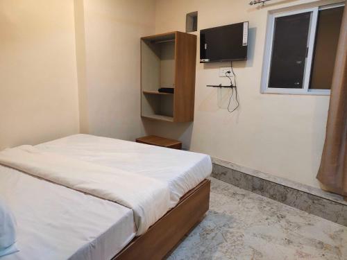 Un dormitorio pequeño con una cama y un televisor. en Hotel O Eleven, en Jabalpur