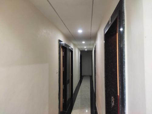 un pasillo con dos puertas abiertas y un pasillo con un pasillo en Hotel O Eleven, en Jabalpur