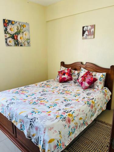 a bedroom with a bed with colorful sheets and pillows at Rayon Bleu A3 two bedroom apartment-perfect sea escape! in Flic-en-Flac