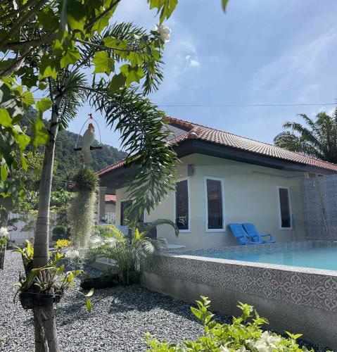 a house with a swimming pool in front of it at Villa Cattleya by orchids pool villas in Ko Lanta