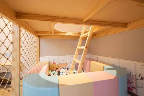 a childs bedroom with a bunk bed with a ladder at Huazhu Xiangshan Tongchen Courtyard in Xiangshan