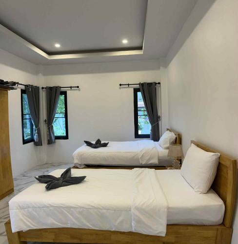 two beds in a room with two windows at Villa Cattleya by orchids pool villas in Ko Lanta