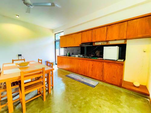 eine Küche mit einem Holztisch und einem Esszimmer in der Unterkunft Serene Villa in Unawatuna