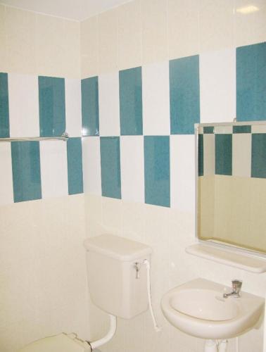 Hotel Kinabalu في كوتا كينابالو: حمام مع مرحاض ومرآة ومغسلة