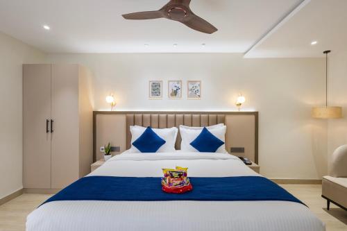 a bedroom with a large bed with blue and white pillows at Regenta Z Sunrise Gachibowli, Hyderabad in Kondapur