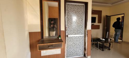 RīngasHotel Sanwariya and Restaurant的把照片放在镜子里的人