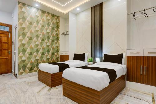 two beds in a hotel room with at Super Townhouse Vishwanath Temple Varanasi in Varanasi