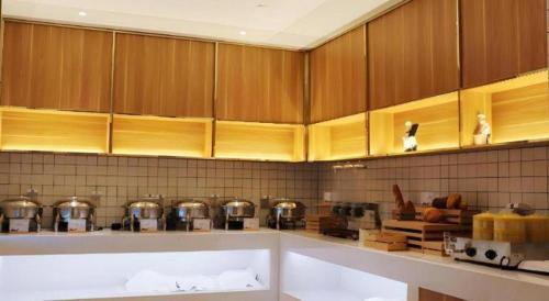 una cocina con armarios de madera, ollas y sartenes en Borrman Hotel Suzhou Wujiang Zhongshan North Road Pedestrian Street, en Suzhou