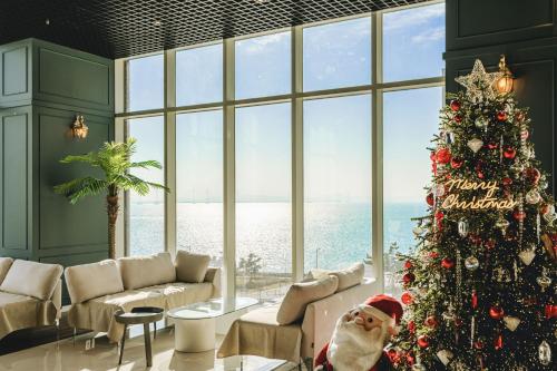 a christmas tree in a room with a large window at Hotel Costa Geobukseom in Siheung