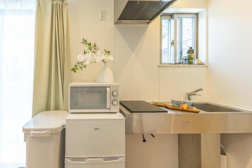 a kitchen with a sink and a microwave at DUA 神楽坂Shinjuku area,train 3 mins,waseda,Kagurazaka in Tokyo