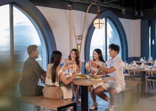 un grupo de personas sentadas en una mesa en un restaurante en Lasong Hotel & Villas Sam Son by The Unlimited Collection, en Sầm Sơn