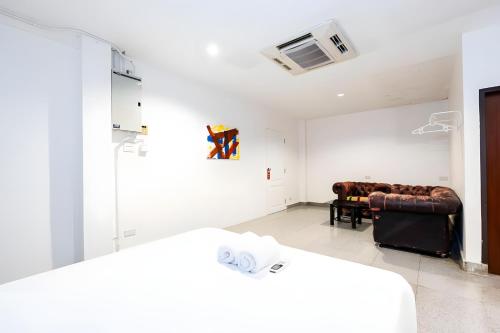 a room with two beds and a couch in it at XX Mitr Inn Sukhumvit 2 - มิตร อินน์ สุขุมวิท 2 in Bang Kapi
