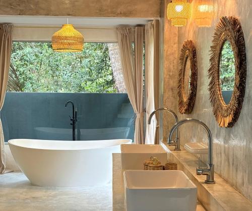 a bathroom with a large tub and a sink at Tropical Garden Luxury Villa, Koh Phangan in Koh Phangan