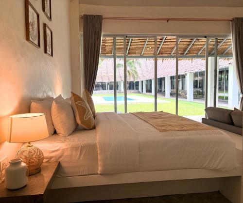 a bedroom with a bed and a large window at Tropical Garden Luxury Villa, Koh Phangan in Koh Phangan
