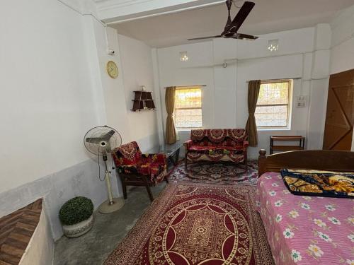 a living room with a bed and a fan at The Indoor Retreat in Siliguri