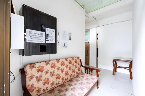 a couch in a room with a tv on the wall at XX Mitr Inn Sukhumvit 2 - มิตร อินน์ สุขุมวิท 2 in Bang Kapi