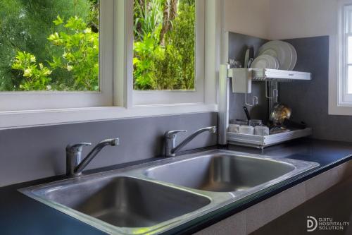 ウブドにあるタマン インドラキラの窓のあるキッチンのステンレス製シンク