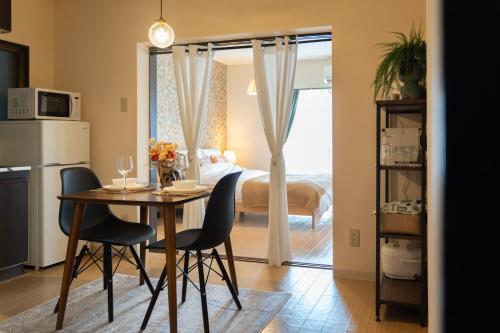 a room with a table and chairs and a bed at 栗林公園の畔 in Takamatsu