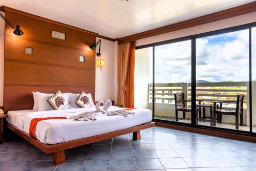 une chambre avec un lit et une grande fenêtre dans l'établissement Hua Hin Loft, à Hua Hin