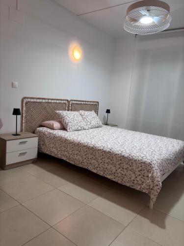 a bedroom with a bed and a dresser and a lamp at Beach Apartament Playa in El Campello