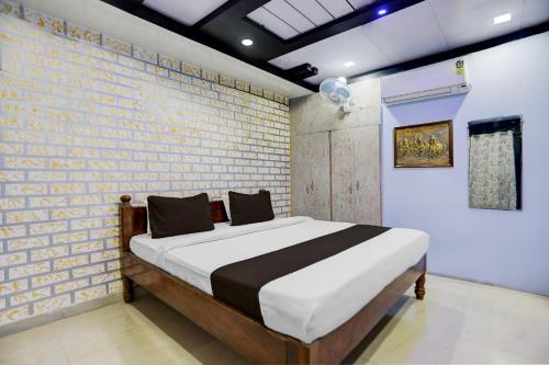Un dormitorio con una cama y una pared de ladrillo. en Super Hotel O Hanuman Nagar Kankarbagh Formerly Home Town, en Bankipur