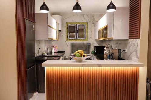 una cocina con una barra con un bol de fruta. en Cozy Luxe Apartment in Central Aswan, en Aswān