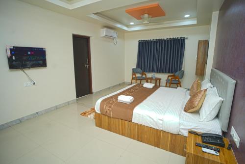 AurangabadにあるHotel Mauli executive & Restaurantのベッドとテレビのある寝室