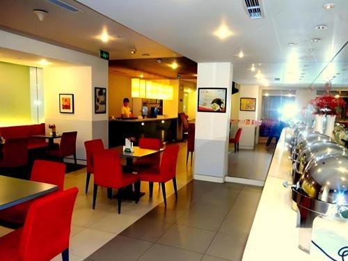 a restaurant with red chairs and tables and a bar at Jinjiang Inn Tianjin Station Jinwan Square in Tianjin