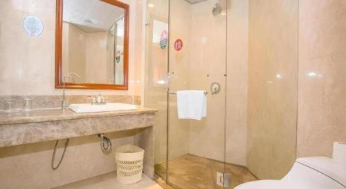 舟山市にあるGreenTree Alliance Zhejiang Zhoushan Putuoshan Zhujiajian Scenic Spot Hotelのガラスのシャワーと洗面台を備えたバスルーム