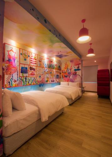 a room with four beds and a painting on the wall at Legend Hotel Kaohsiung Pier2 in Kaohsiung