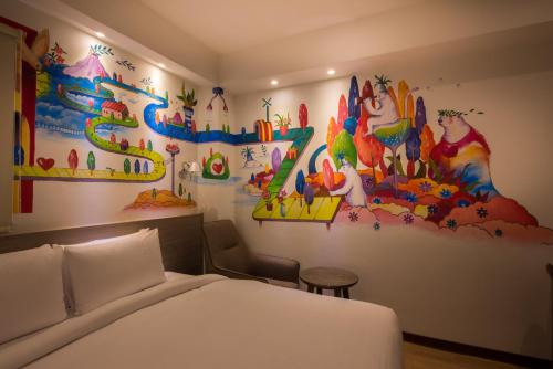 a bedroom with a bed and a painting on the wall at Legend Hotel Kaohsiung Pier2 in Kaohsiung