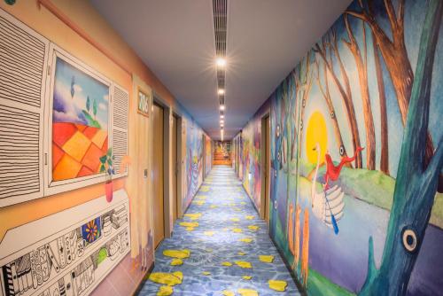 a hallway with colorful murals on the walls at Legend Hotel Kaohsiung Pier2 in Kaohsiung