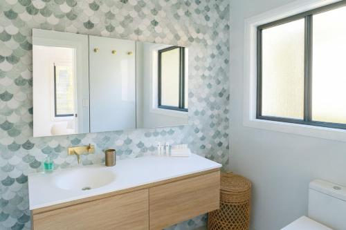 Hibiscus Haven 1BR getaway in Valla Beach في Valla Beach: حمام مزود بحوض ومِرآة