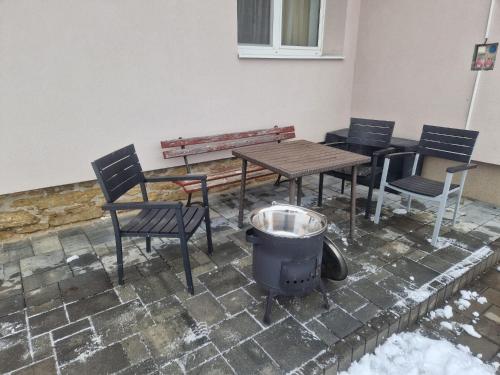 eine Terrasse mit Tisch, Stühlen und Grill in der Unterkunft Villa Rustica in Bešeňová