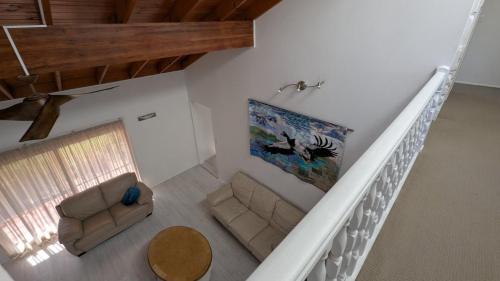 a living room with a couch and a painting on the wall at Flamingo Sunset Retreat in Old Bribie
