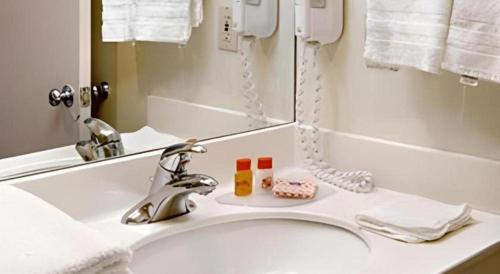 a bathroom sink with two bottles of soap and a mirror at Shalimar Hostel in Las Vegas